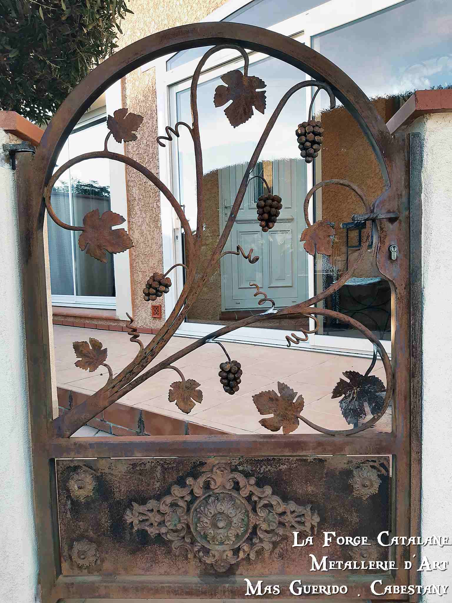 portillon cintre ouvrage remplissage cep de vigne avec grappes de raisin soubassement tole avec palmette forge catalane.jpg